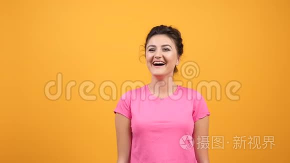 穿着粉红色T恤的年轻女子，带着自然的情绪笑着笑着