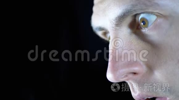 恐惧的眼神,黑色背景下年轻男人的眼睛短视频