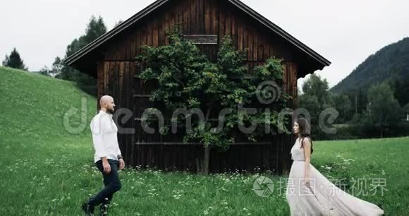 在田野的中间，一对神奇的夫妇在一座小木屋前相遇