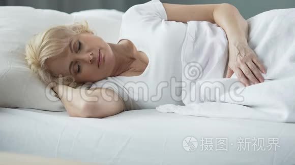 快乐的中年女性睡在床上的骨科床垫，健康