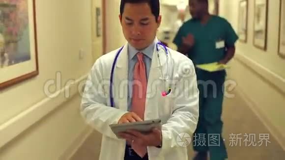 医生使用数码平板电脑沿医院走廊行走