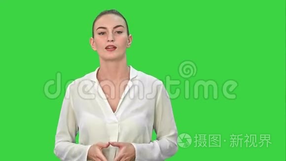 一位年轻的商业女性的肖像，用一只手在绿色屏幕上呈现一些东西，Chroma键。