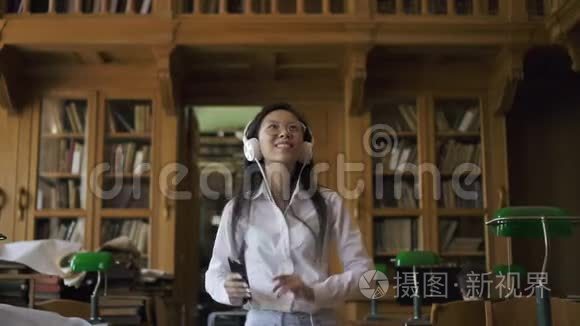 穿着白衬衫戴眼镜听音乐的年轻亚洲女人