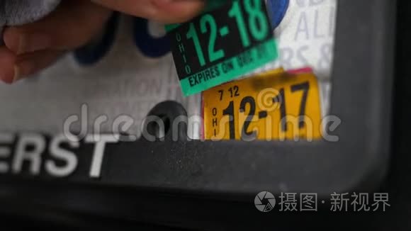 女人在车牌上贴上新的过期标签视频