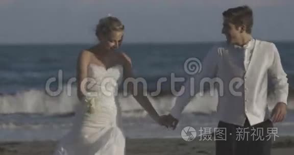 微笑着新婚夫妇在海滩上奔跑