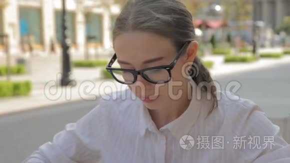 带报纸的户外咖啡馆里的白种人女学生。