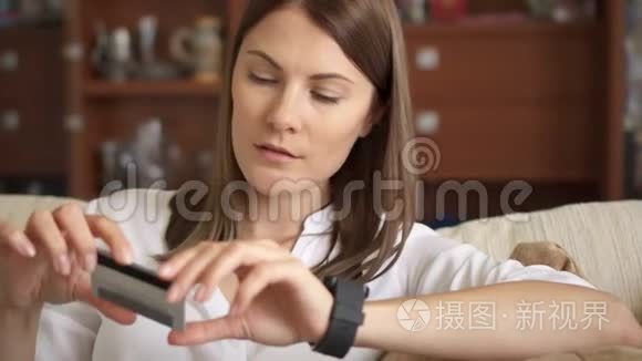 美丽的女性网上银行使用智能手表在线购物与信用卡家庭生活方式