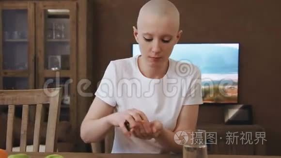 癌症病人的女人坐在桌边吃药