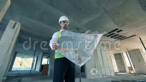 一个工人，一个穿制服的专业建筑工人站在一座建筑里，开射击。