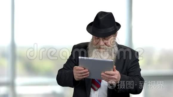 兴奋的老人拿着平板电脑。