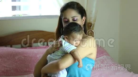 拉美裔拉丁裔母亲把流口水的婴儿抱在肩膀上，然后在背部轻敲，这样婴儿就可以打嗝了