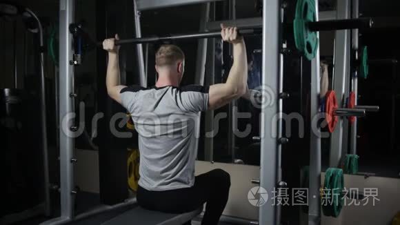 年轻的肌肉男在健身房训练视频