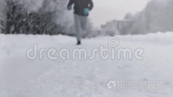 冬天在公园里沿着雪道奔跑的人的剪影