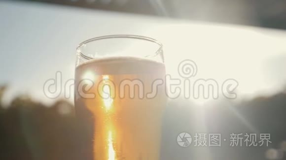 一杯冰啤酒贴在天空，一个黄色的夕阳