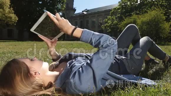 可爱的女学生在公园用平板电脑学习