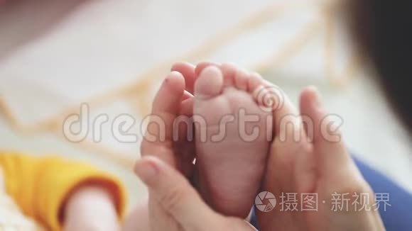 婴儿的脚在母亲的手中。小宝宝的脚放在女性心形的手上特写。妈妈和她的孩子。幸福家庭观。