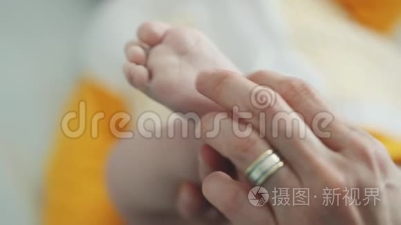婴儿的脚在母亲的手中。小宝宝的脚放在女性心形的手上特写。妈妈和她的孩子。幸福家庭观。