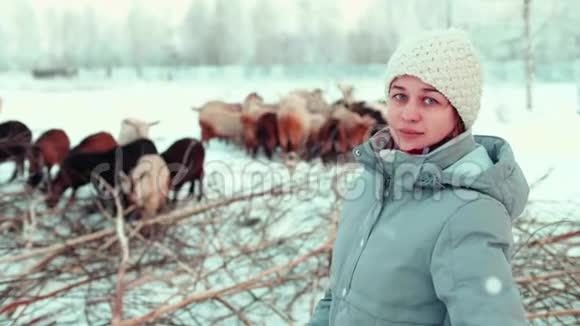 漂亮的农民女孩蓝眼睛自信地笑着背景是山羊视频的预览图