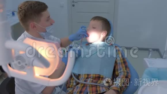 牙科冲洗男孩`的嘴水，保持唾液喷射器在卫生清洁。