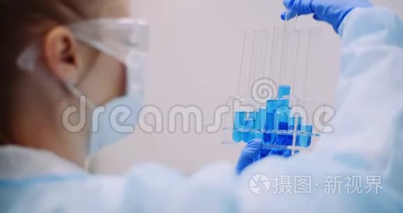 科学家在实验室持有测试管和寻找病毒治疗。