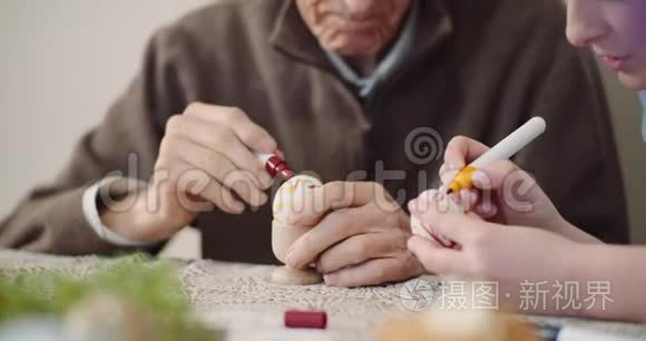 年长的男人和女人在画鸡蛋