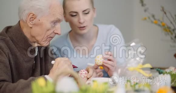 年长的男人和女人在画鸡蛋视频