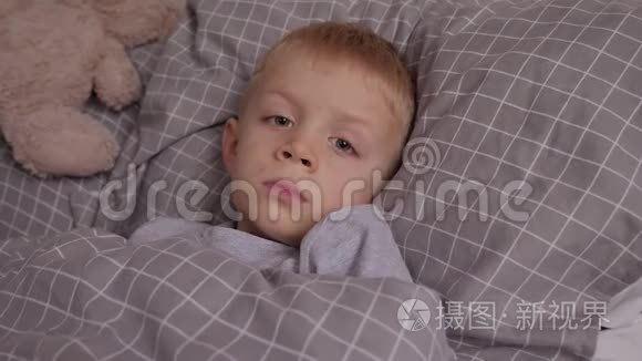 一个有水痘和红疹的小男孩躺在床上。