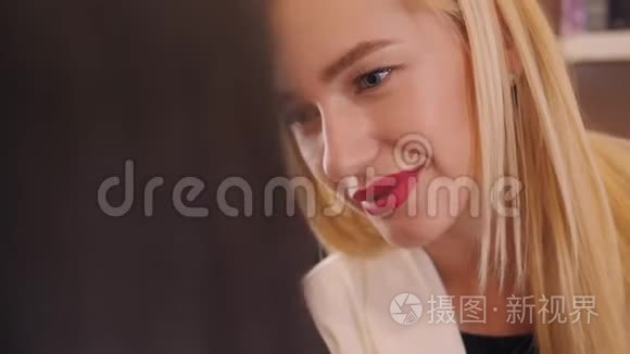 一位年轻女性化妆师在美容院的红唇膏画像。