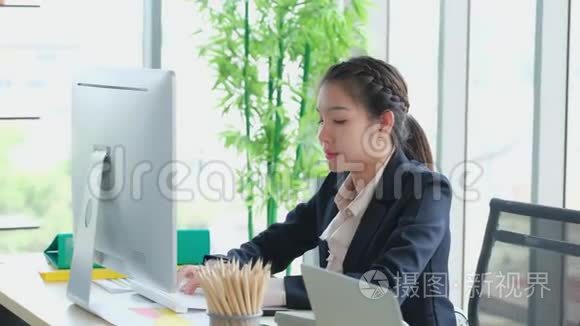 早上，年轻的亚洲女性独自在办公室打字。 从事计算机工作的商业妇女