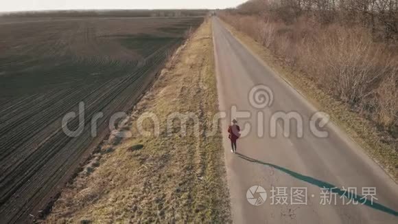 女农民用数码平板电脑观看冬天后新开垦的田地，她计划