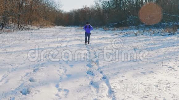 背着背包在白色冬日森林里徒步旅行的人。雪天户外休闲健康生活。旅行