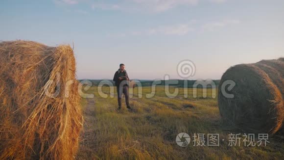 青年农民在田间手持平板电脑，并利用技术预测未来农业增长。 智能智能智能