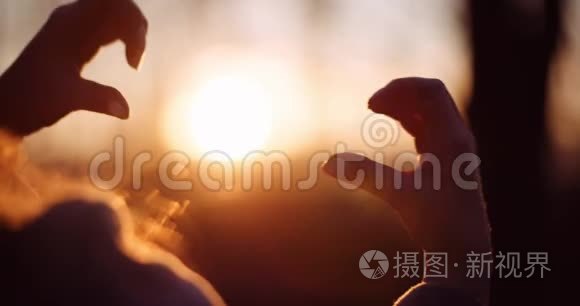 女人用心形的手在阳光下视频