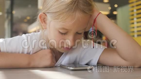 快乐的女孩看起来很聪明。 小女孩玩手机。 教育、学校、技术和互联网概念。