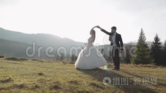 新婚夫妇。 白人新郎和新娘在山坡上跳舞。 新婚夫妇