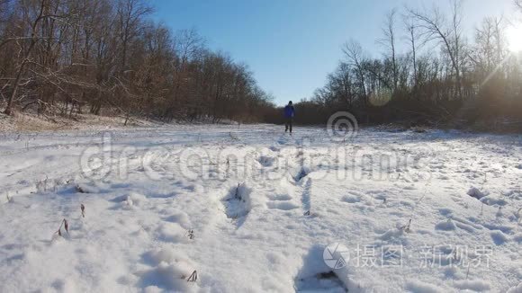 背着背包在白色冬日森林里徒步旅行的人。雪天户外休闲健康生活。旅行