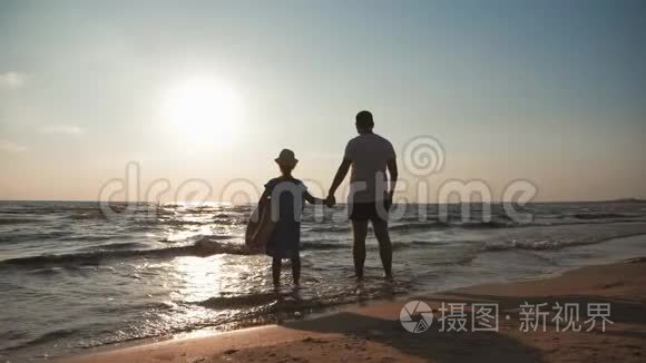 剪影父女在日落时在海滩上玩耍。 友好家庭，旅游，生活方式的概念..