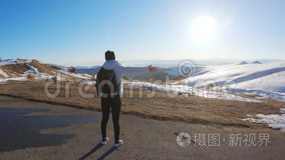 成功的女徒步旅行者在空中张开双臂后，徒步到山顶的云层之上。