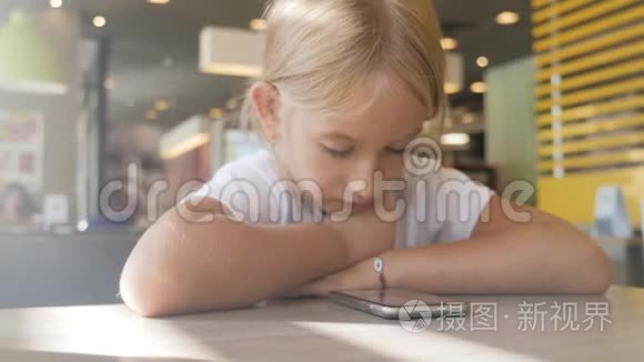 快乐的女孩看起来很聪明。 小女孩玩手机。 教育、学校、技术和互联网概念。