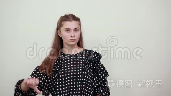 穿着白圈黑衣服的女孩愤怒的愤怒的女人竖起大拇指