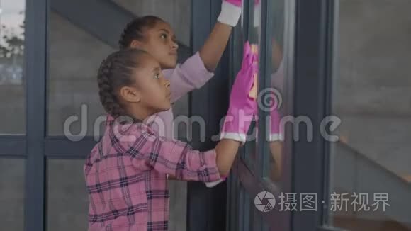 女孩用清洁用品清洗窗户玻璃