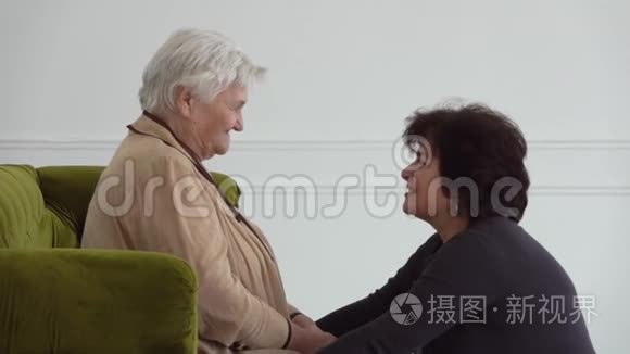 美丽的女人在白屋子里和年迈的母亲说话