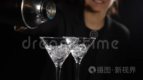 女调酒师准备亮蓝色鸡尾酒，从摇床上倒出液体。 用冰做酒精鸡尾酒