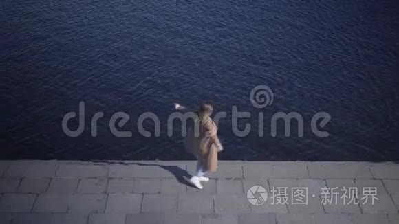 乐观的白人年轻女子在河岸上旋转的俯视图。 大片快乐胖乎乎的女孩享受阳光