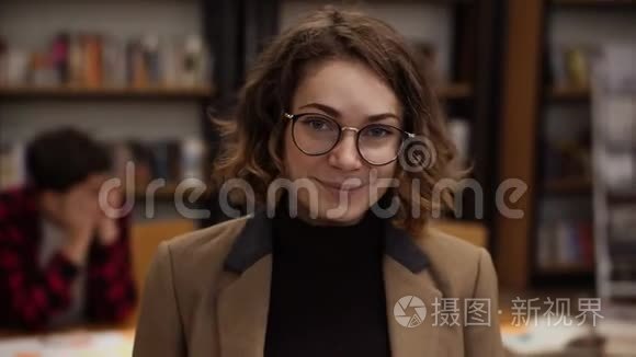 一位戴着眼镜、长着短头发的欧洲女学生站在高中图书馆微笑着的肖像