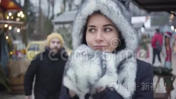 戴着黑白帽子和手套的白种人女人站在户外，男人从户外走来的画像