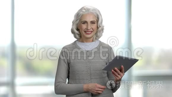 肖像和老太太拿着平板电脑和谈话。