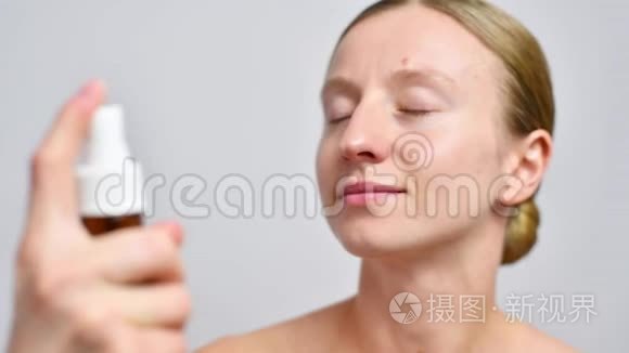 美丽的女人在脸上喷着微波视频