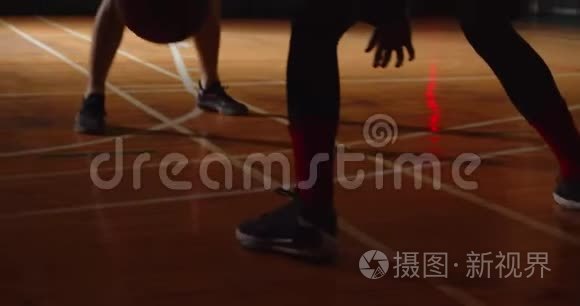 两个年轻的篮球运动员打篮球比赛业余爱好者大厅体育球拍运球耐力晚上结束