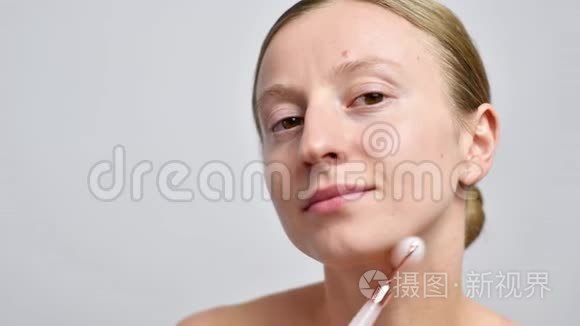 不化妆的女人用玉辊按摩脸部视频